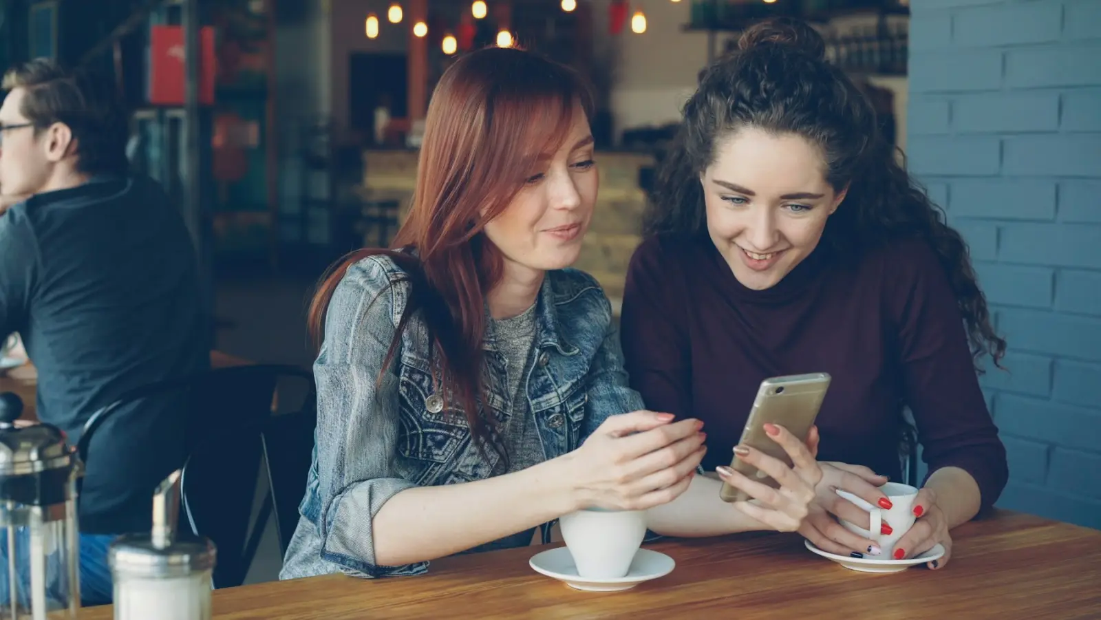 两位朋友看着智能手机微笑